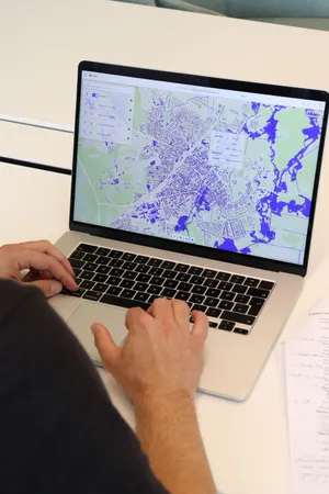 Man sieht eine Karte auf einem Laptop-Bildschirm und die Hände, der Person am Laptop