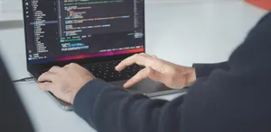 Man sieht einen Programmiercode auf einem Laptop
