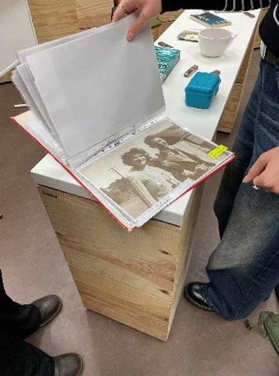 Das Foto zeigt einen Ordnern der durch eine Person geöffnet wird. Darin zu sehen sind Archiv Aufnahmen der Familie Löwenthal.