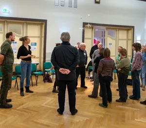 eine Gruppe von Menschen steht zusammen in einem Semiarraum