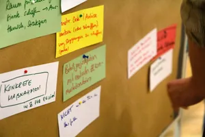 Eine Pinnwand mit beschriebenen bunten angepinnten Zetteln.