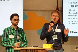 Zwei Personen sprechen in ein Mikrophon und präsentieren ihr Thema.