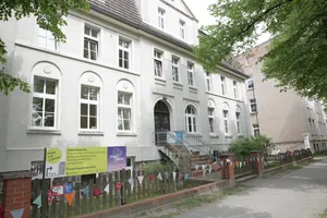 Zu sehen ist die Fassade eines weißen Hauses