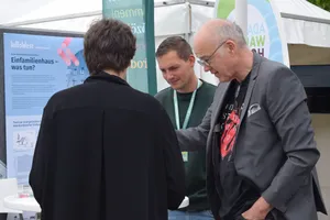 Drei Personen unterhalten sich am Stand "Einfamilienhaus - Was nun?" von InNoWest.