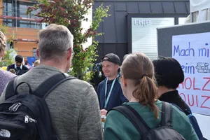 Mehrere Menschen am Stand des Holz-Quiz.