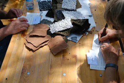 Mehrere Menschen sitzen an einem Tisch und testen verschiedene Materialien.