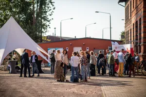 Zu sehen ist der Vorplatz des Transferorts in Wittenberge zur feierlichen Eröffnung mit zahlreichen Menschen gefüllt.
