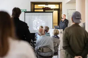 Ein Mann hält eine Präsentation vor einer Gruppe von Zuhörern.  