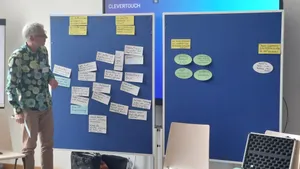 Zu sehen ist Prof. Dr. Benjamin Nölting vor zwei Stellwänden mit beschrifteten Kärtchen.