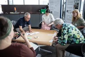 Workshoptisch mit konzentriert arbeitenden Mitarbeitenden 