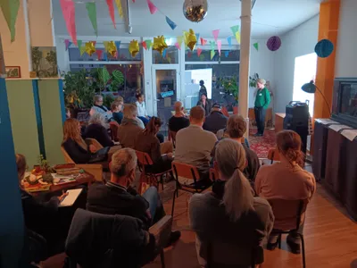 Zu sehen ist ein Veranstaltungsraum mit einigen Menschen 