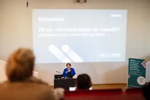 Eine Frau hält eine Präsentation vor einem großen Publikum.