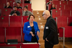 Ein Mann und eine Frau unterhalten sich in einem Vorlesungssaal.  