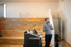 Ein Mann steht an einem Rednerpult und spricht in ein Mikrofon