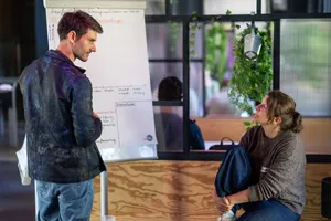zwei Menschen diskutieren vor einem Flipchart
