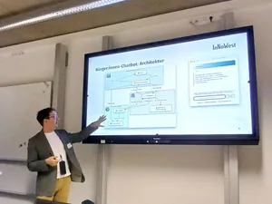 Ein Mann steht vor einem Whiteboard und zeigt auf eine Grafik auf dem Whiteboard