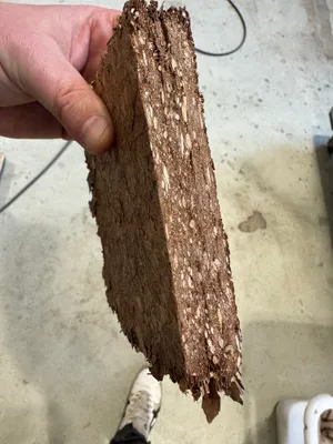 Festkörper aus Laubmaterial in einer Hand