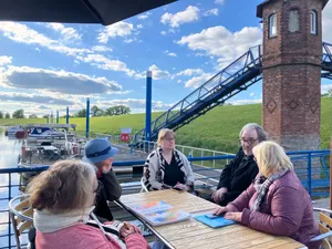 5 Menschen an einem Tisch im Gespräch an der Elbe