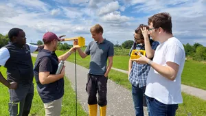 Auf dem Bild ist eine Gruppe von Personen zu sehen, die um einen Sensor stehen